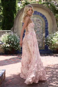 Élégante robe longue fleurie à dos nu avec volants étagés dans un jardin.