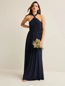 Detail view of a navy blue halter-neck maxi dress with elegant pleats and soft draping.