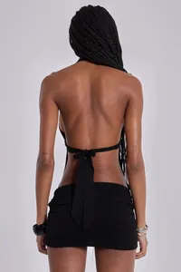 Back view of a black halter neck backless mini dress with tie-up detail