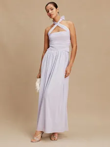 Elegantly styled model in a lavender multi-way pleated maxi dress against a tan backdrop