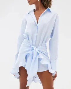Detail view of light blue shirt dress featuring a stylish waist tie-knot and ruffles