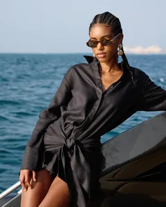 Fashionable black long sleeve shirt dress with tie-waist detail worn by model on yacht