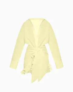 Detail view of this elegant pale yellow tie-front shirt dress featuring a ruffled hem