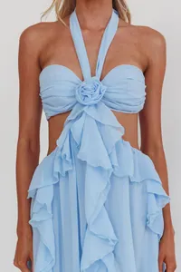 Dettaglio di un abito lungo azzurro a sottoveste con decoro di rose e volant