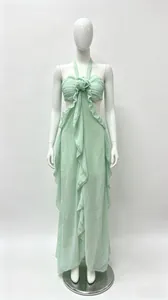 Dettaglio ravvicinato dell'abito lungo verde menta con fiore in 3D e volant eleganti.