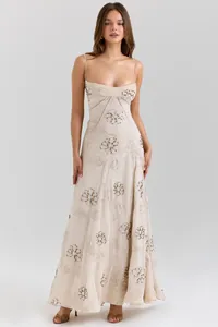 Full-length view of a sleeveless beige dress with brown floral embroidery detail