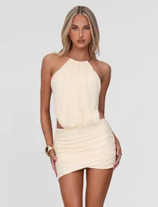Close-up of elegant cream halter neck top with gold ring and matching ruched mini skirt