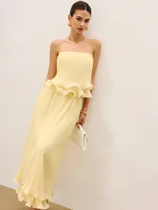 Dettaglio degli eleganti bordi a balze su questo set a due pezzi plissettato giallo