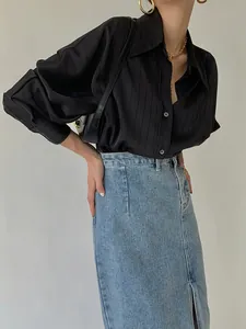 Gros plan d'une chemise en satin noir à rayures montrant une texture soyeuse haut de gamme
