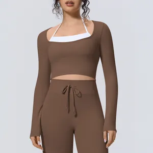 Λεπτομέρεια του καφέ fake two-piece yoga top με λευκές εσωτερικές τιράντες