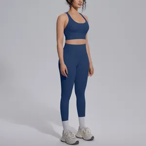 Dark blue two-piece yoga set with cross back bra and high-waisted leggings on model