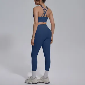 Back view of navy blue yoga set featuring cross-strap sports bra and high-waist leggings.