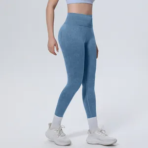 Detail of high-waisted seamless washed blue yoga leggings with tummy control feature.