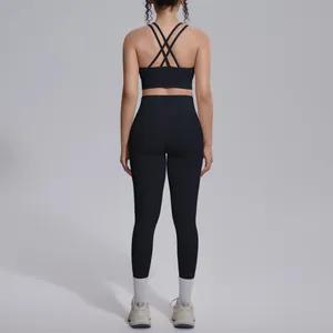 Back view showing detail of black crisscross sports bra and high-waisted leggings set