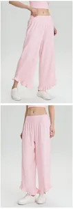 Detailweergave van de roze wijde broek met hoge taille en ruches aan de zoom