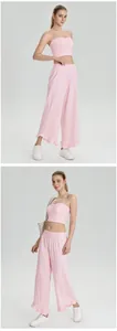 Vue complète d'un ensemble de yoga rose avec haut bandeau et pantalon large à volants.
