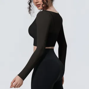 Dettaglio della trama in rete traspirante del crop top da yoga nero a due strati per donna