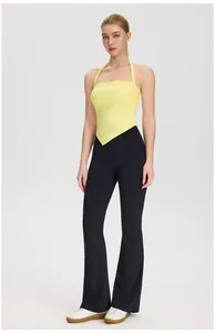 Close-up of yellow halter neck yoga tank top with pointed hem and black flare pants