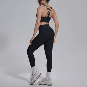 Back view of black two-piece yoga set featuring criss-cross back bra and high waist leggings.