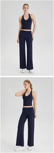 Volledig zicht op marineblauwe halter yoga top en wijde broek op model