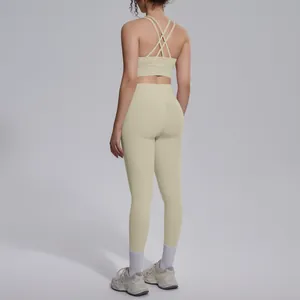 Rear view of a beige women's cross-back sports bra and high-waisted yoga leggings set.