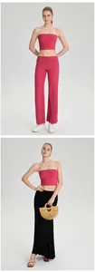 Detail van een roze strapless yoga bandeau top gedragen met een broek en lange rok.