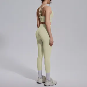 Pale green two-piece yoga set with criss-cross back sports bra and high-waist leggings.