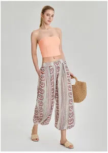 Vue en pied d'un mannequin portant un haut bandeau de yoga orange sans bretelles.