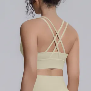 Dettaglio di un reggiseno sportivo beige con spalline incrociate per yoga e fitness.