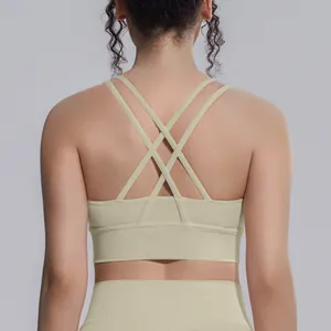 Vista posteriore dettagliata di un reggiseno sportivo beige con spalline incrociate.