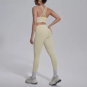 Back view of a cream yellow yoga set with a criss-cross sports bra and high-waisted leggings.