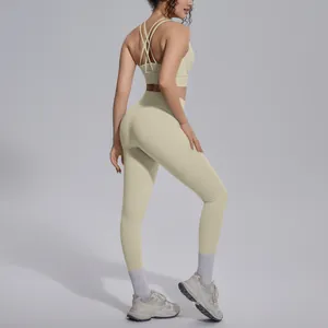 Back view of woman wearing a beige criss-cross sports bra and high-waisted yoga leggings