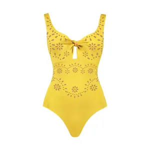 Detailed macro view of yellow one-piece swimsuit with floral laser-cut hollow patterns.