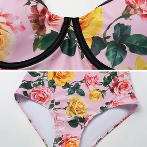Detailopname van een roze badpak uit één stuk met prachtige bloemen en rozenprint