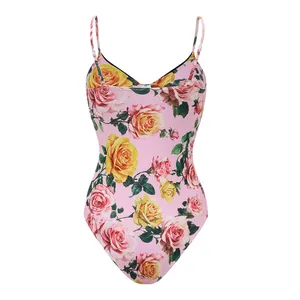 Detail van roze badpak uit één stuk met een levendig geel en roze rozenbloemenpatroon.