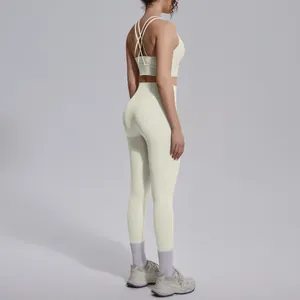 Detail shot of a cream-colored yoga set featuring cross back bra and high-waist leggings.