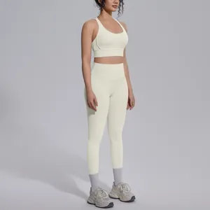 Two-piece cream yoga set featuring a cross back sports bra and high-waisted leggings