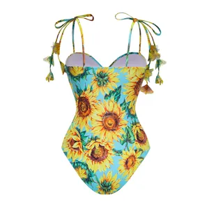 Detailed view of light blue one-piece swimsuit with vibrant sunflower print and tie straps