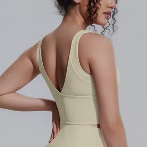 Dettaglio di un reggiseno sportivo beige con profondo scollo a V sulla schiena per lo yoga.