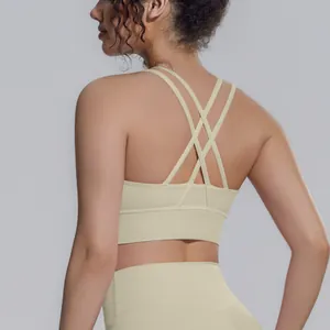 Dettaglio ravvicinato di un reggiseno sportivo beige con spalline incrociate per lo yoga