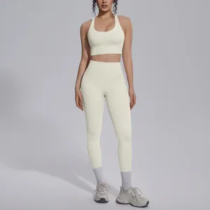 Full body view of a cream-colored nylon sports bra and leggings athletic yoga set on a model