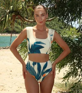 Detailansicht eines hochtaillierten Damen-Bikinis mit tropischem Blattmuster am Strand.