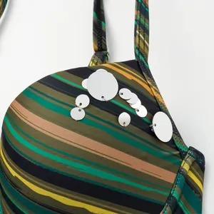 Close-up of silver sequins on striped color-block fabric of women's swimsuit