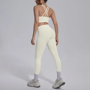 Back view of cream yoga set showing criss-cross sports bra and high-waisted leggings