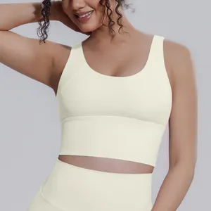 Dettaglio ravvicinato di un reggiseno sportivo da yoga bianco crema su modella femminile.