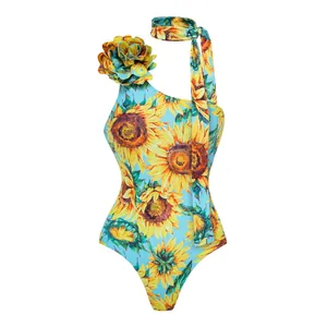 Detail view of blue one-piece swimsuit with vibrant sunflower print and 3D flower.