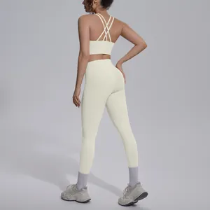 Detail view of a cream-colored yoga set featuring a cross-back sports bra and leggings.
