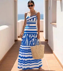 Vestido largo escalonado a rayas azules y blancas llevado por una modelo en un entorno costero