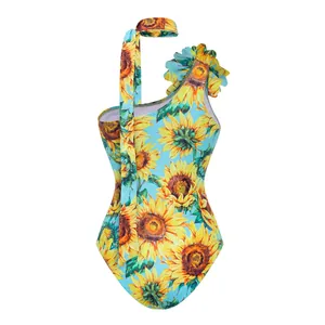 Close-up view of a vibrant sunflower print one-piece swimsuit with matching neck scarf detail