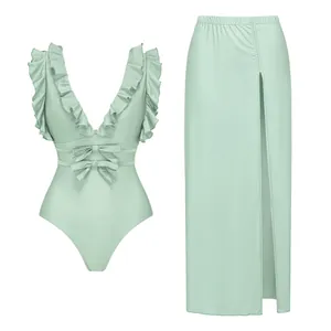 Ensemble maillot de bain vert menthe avec haut à volants et jupe longue fendue assortie.
